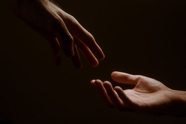 Photo of two hands reaching out for each other