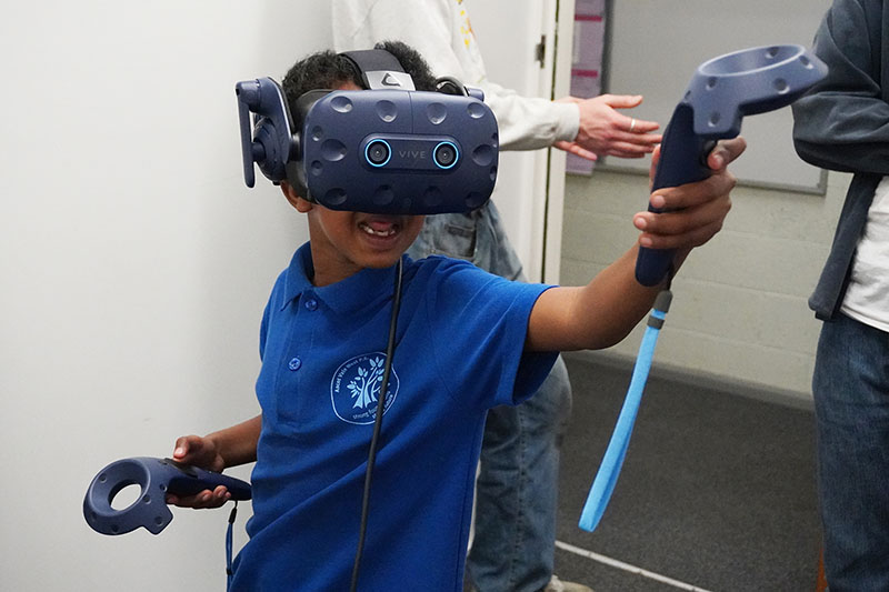 A child in a VR headset enthusiastically moves around the room