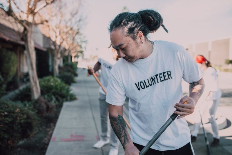 Volunteers sweeping footpath.