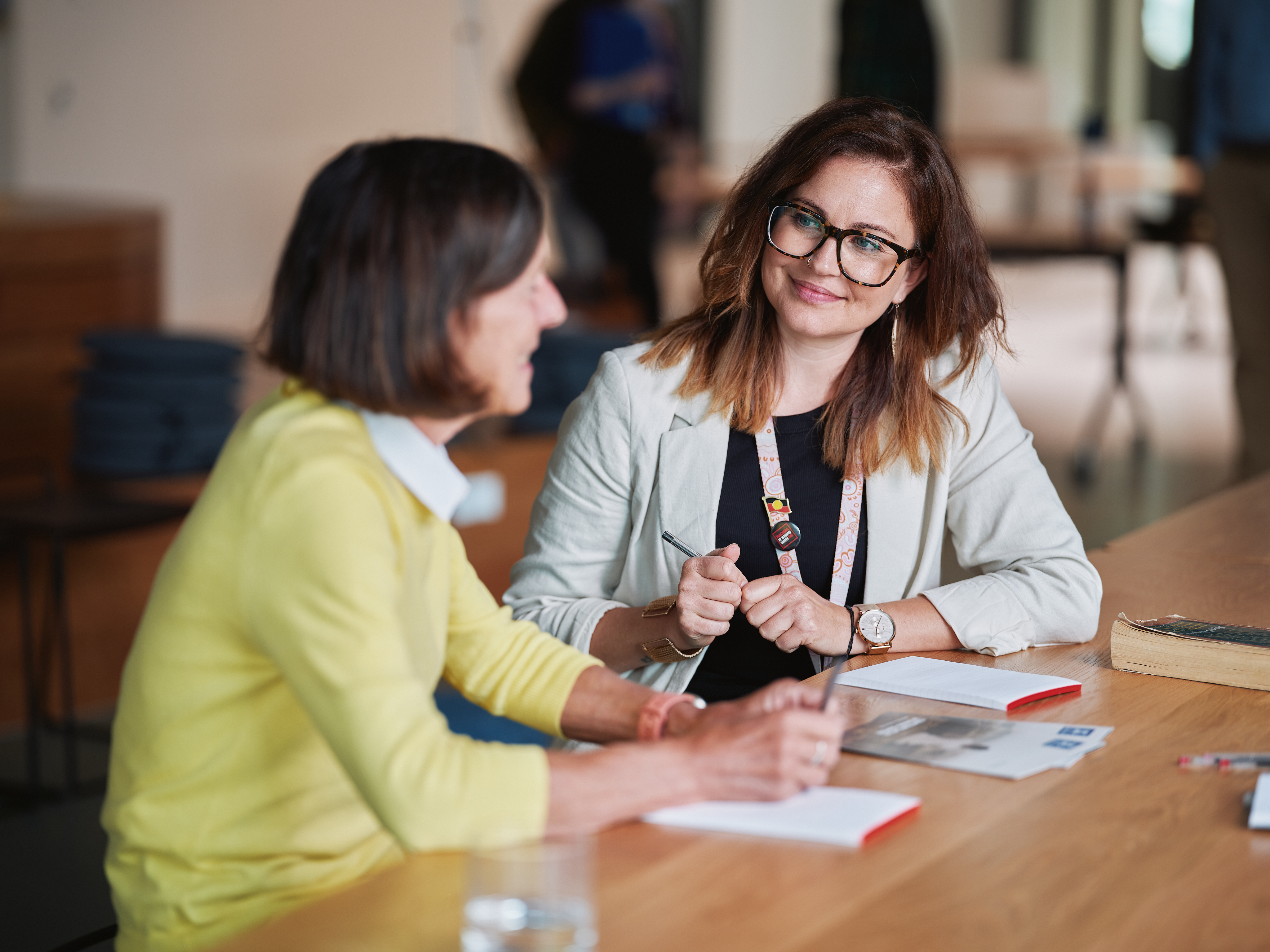 Two people talking at desk