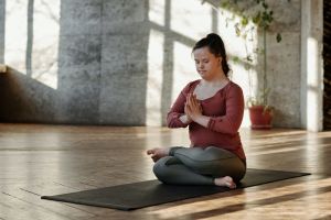 Woman meditating cross-legged on a mat